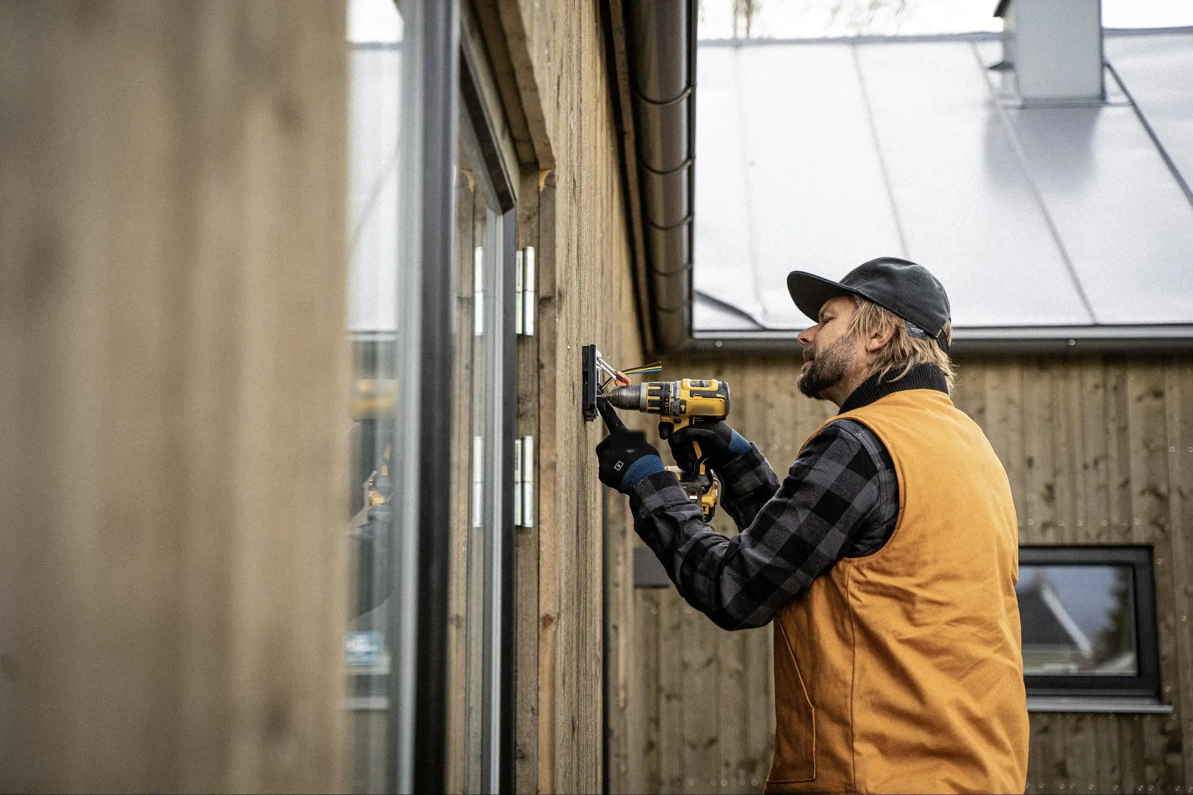 Elektriker monterer en lampe på en trevegg